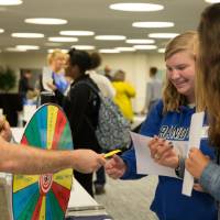 A residence hall staff member plays a game with two students